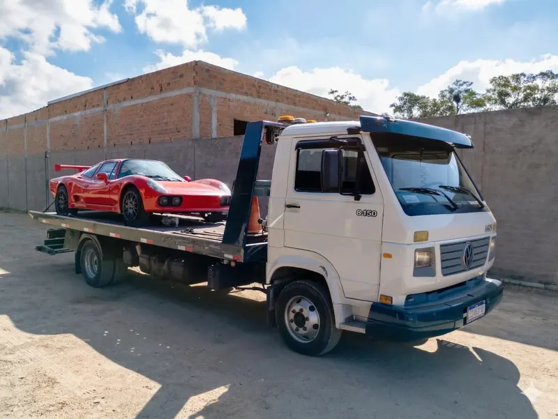 Guincho pesado transportando veículo em prancha