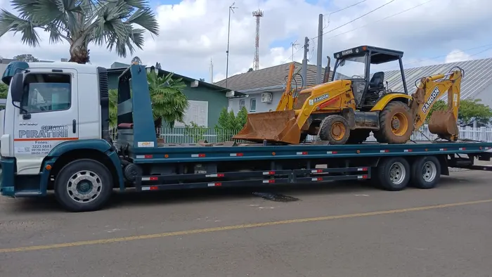Retroescavadeira transportada em prancha pela Guinchos Piratini